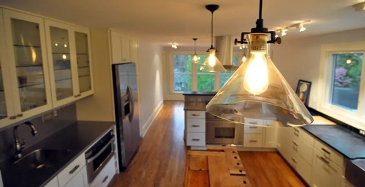 Residential electrician installing modern indoor light fixture in a home in Fresno, CA